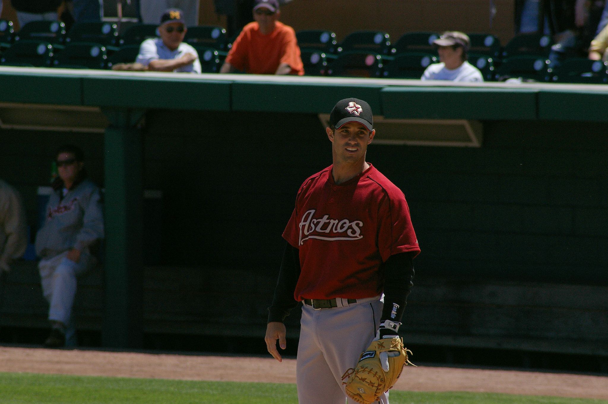 a man in a red jersey holds his baseball glove