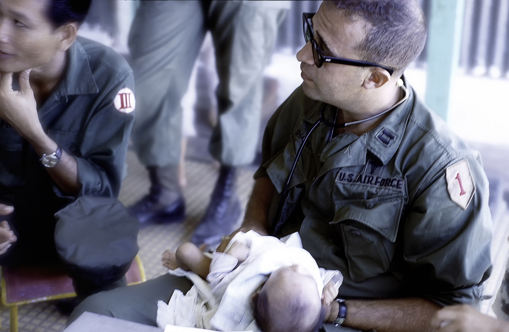 a man in military clothing is holding a baby