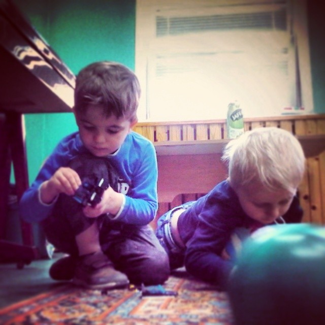 two s are playing with toys in their living room