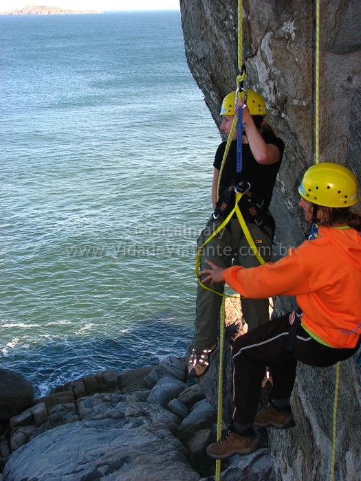 people on the side of a cliff roped by ropes