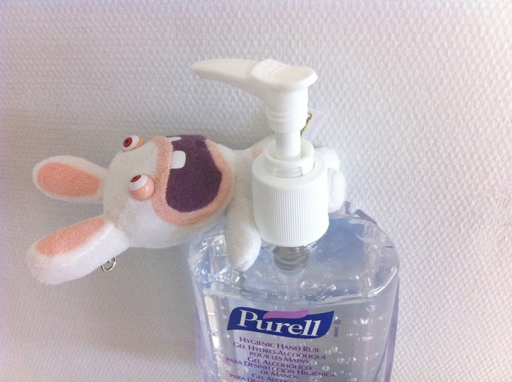 a bottle of hand sanitizer next to a stuffed animal