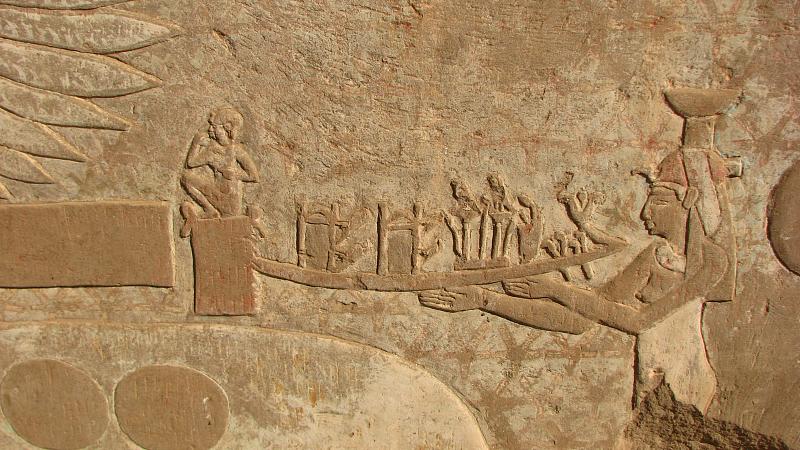 an egyptian sculpture depicts a man sitting on a boat