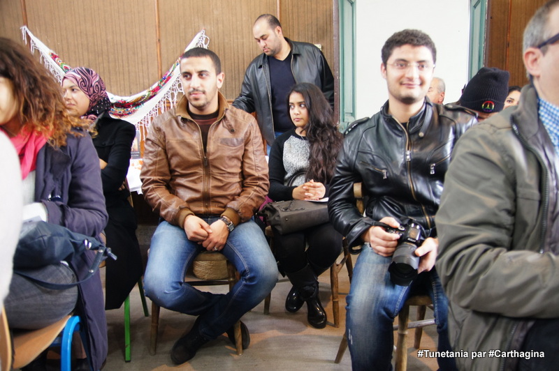 a group of men and women sit in chairs