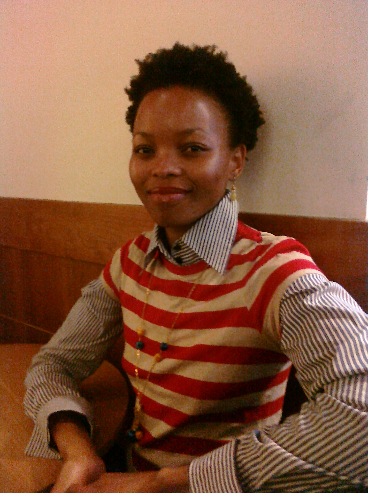 a young african woman wearing a striped shirt and striped tie