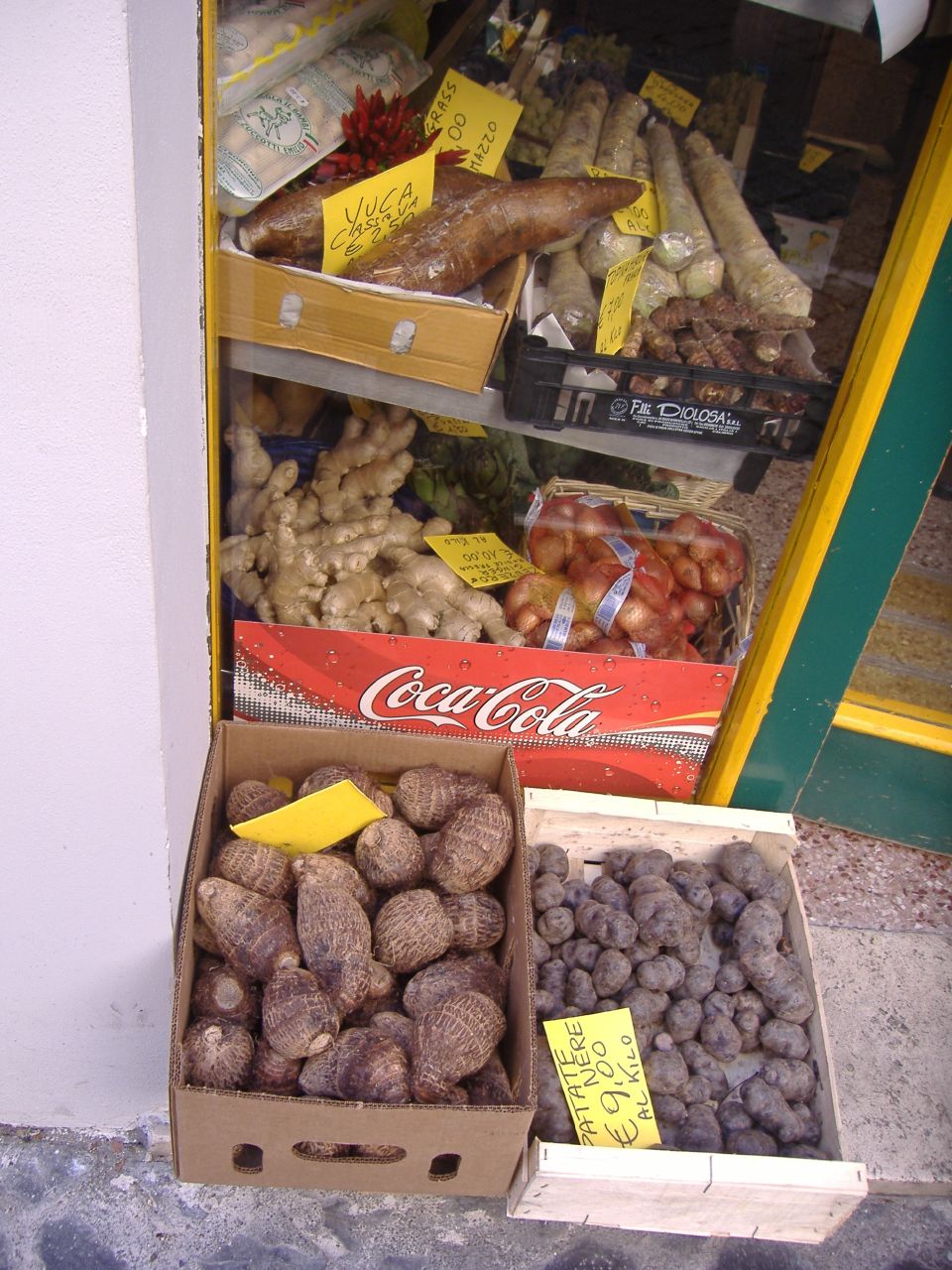 two boxes of potatoes with tags on them outside