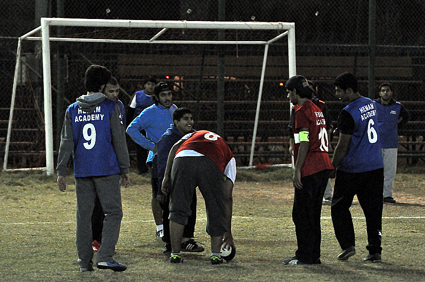 a group of people on a field near a goal