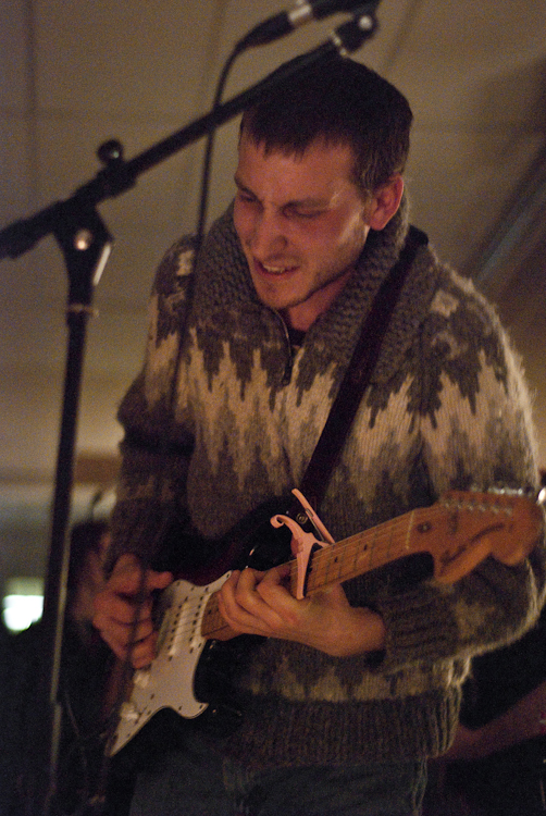 there is a young man playing a guitar