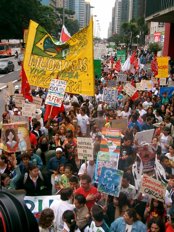 a large group of people with signs and flags on the street