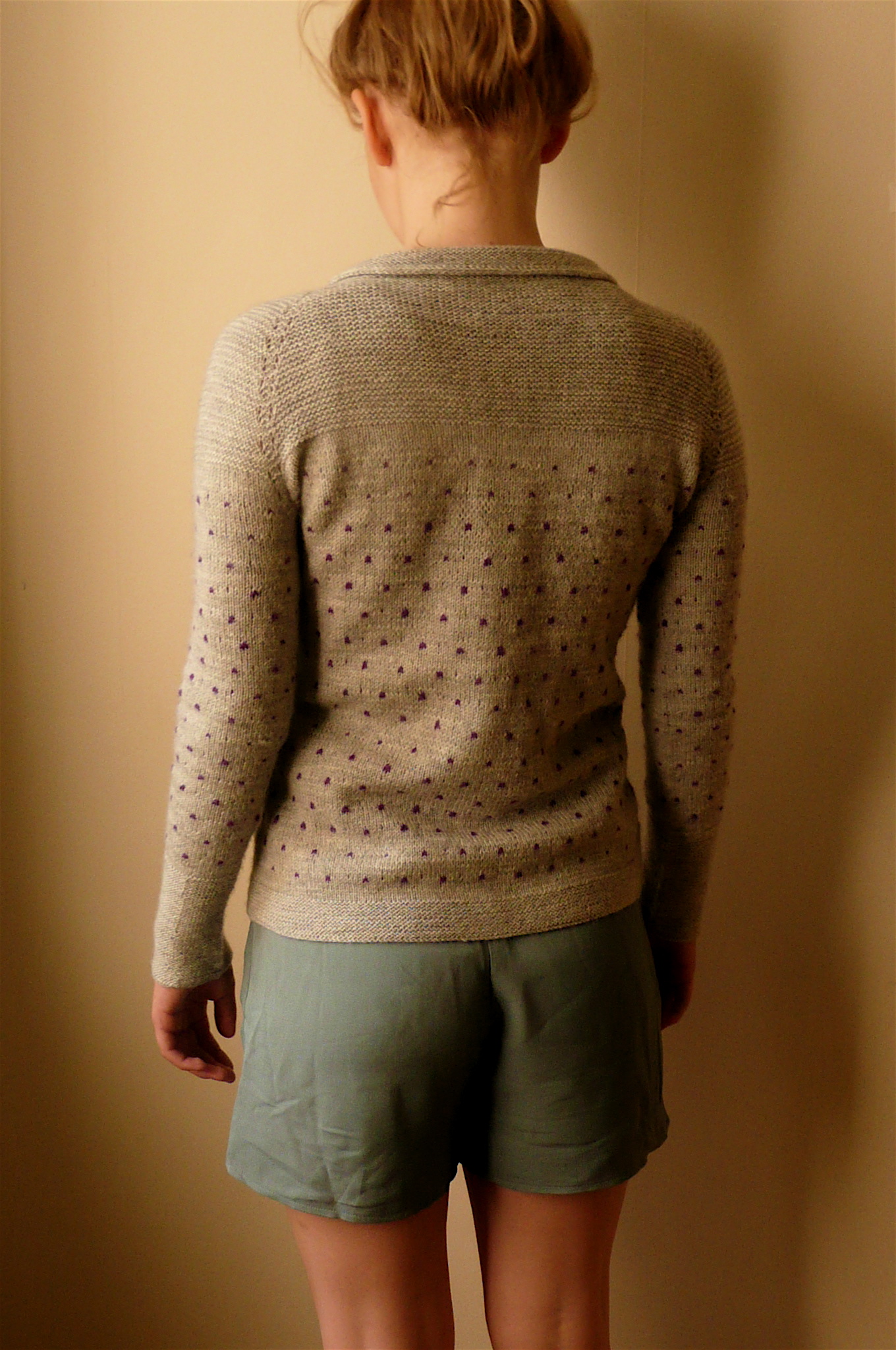 the back view of a woman's short wearing a sweater