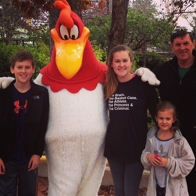 a group of people and a person in a rooster costume