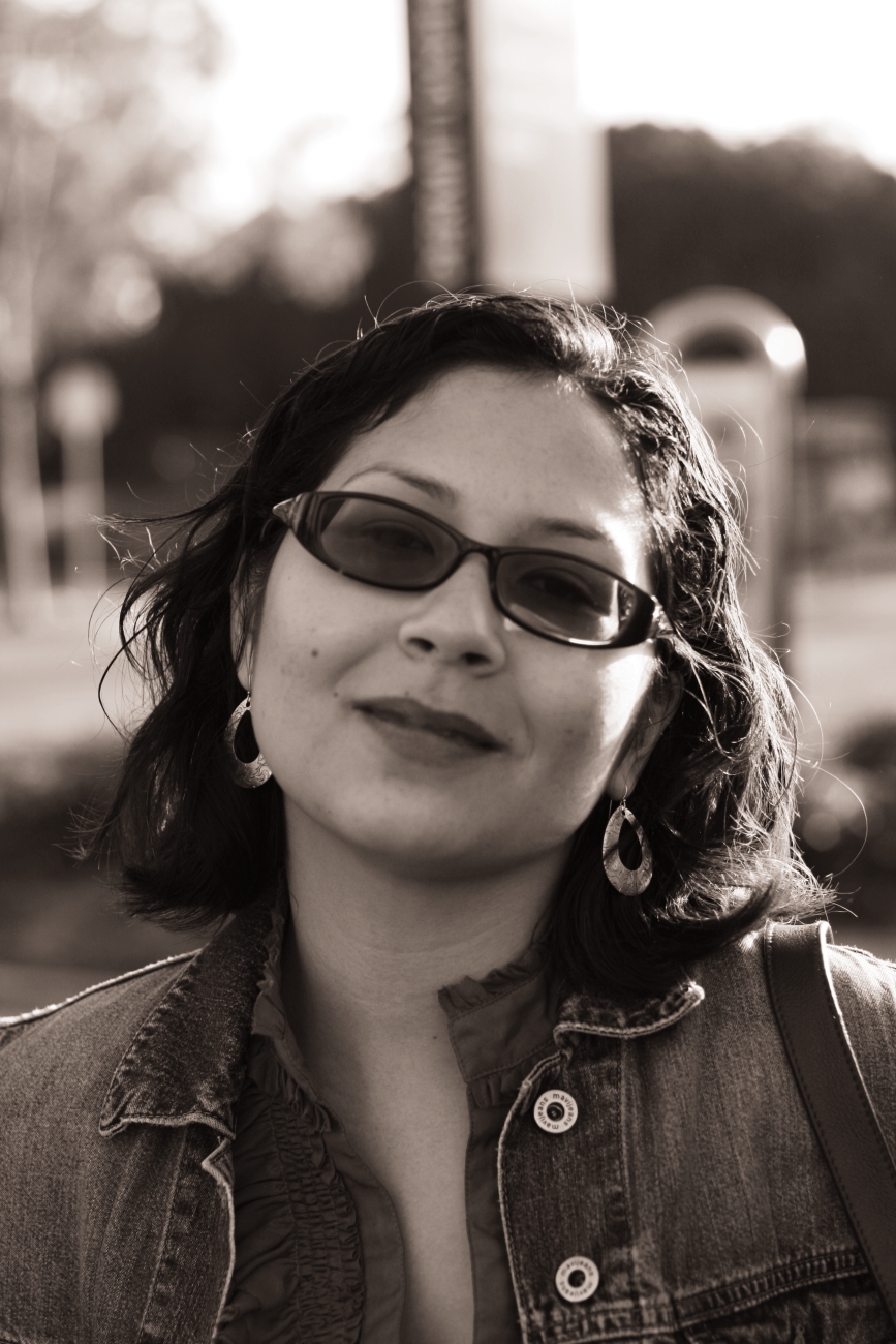 a girl wearing glasses leaning against a wall