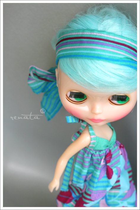 a doll wearing a blue dress with striped hair