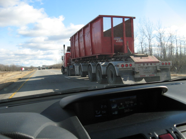a semi truck on the highway with some large red containers
