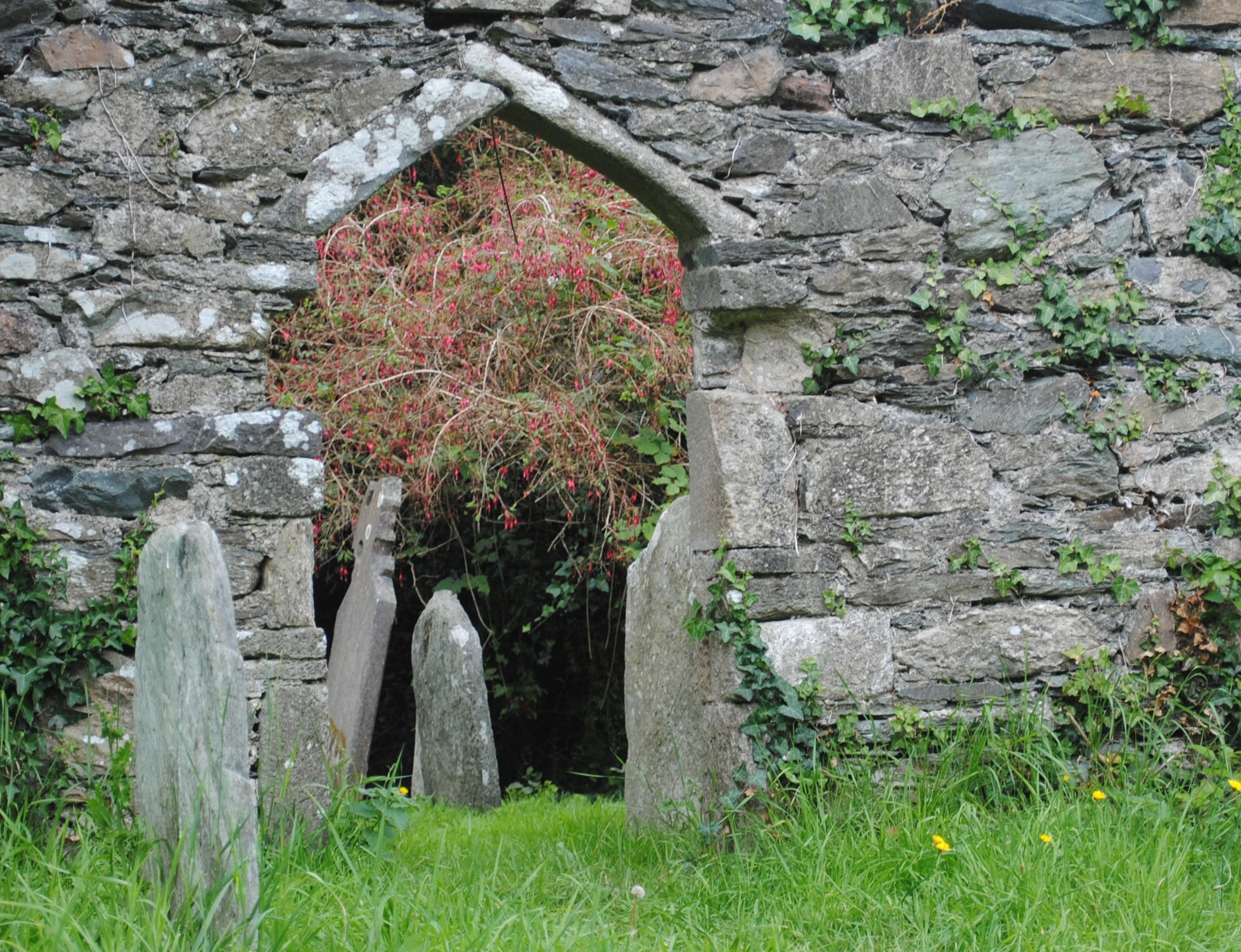 a small entrance to a cemetery with stone walls