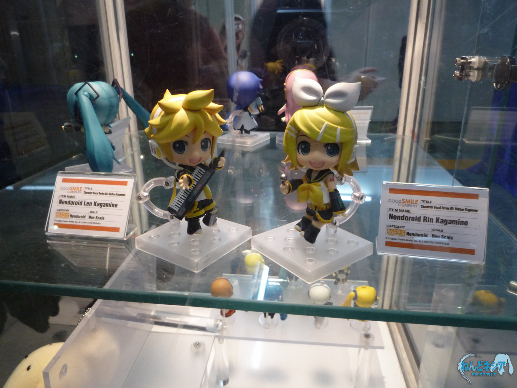 two anime figurines sitting on display in a glass case