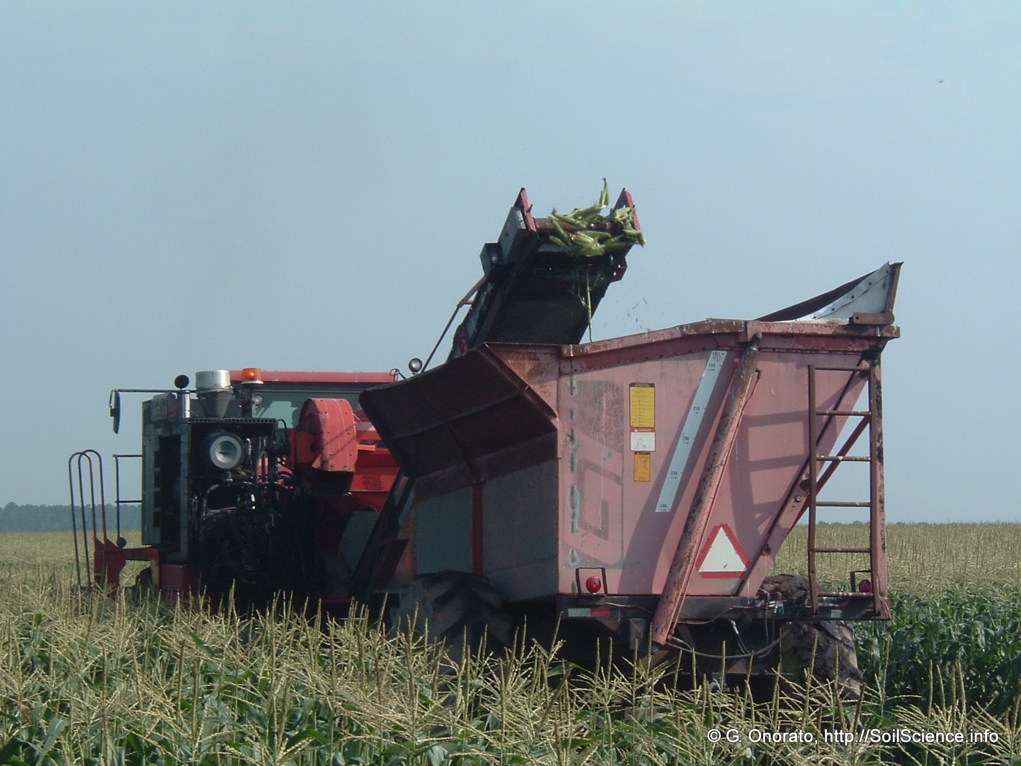 a tractor is dumping some siltes in a field