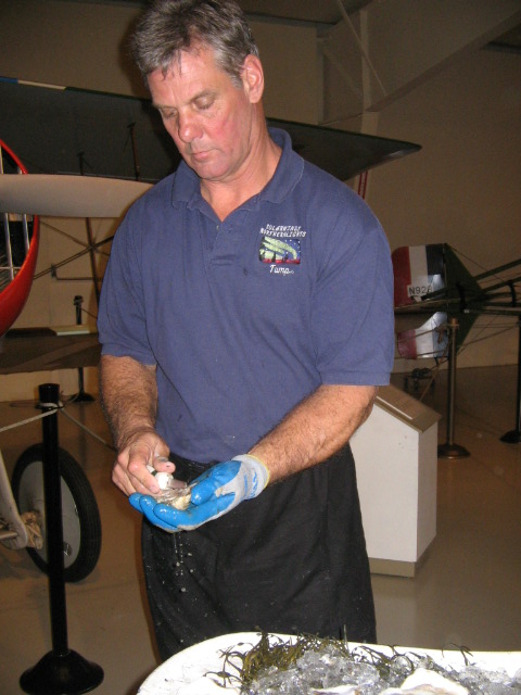 a man standing in front of a table holding a plastic container with water on it