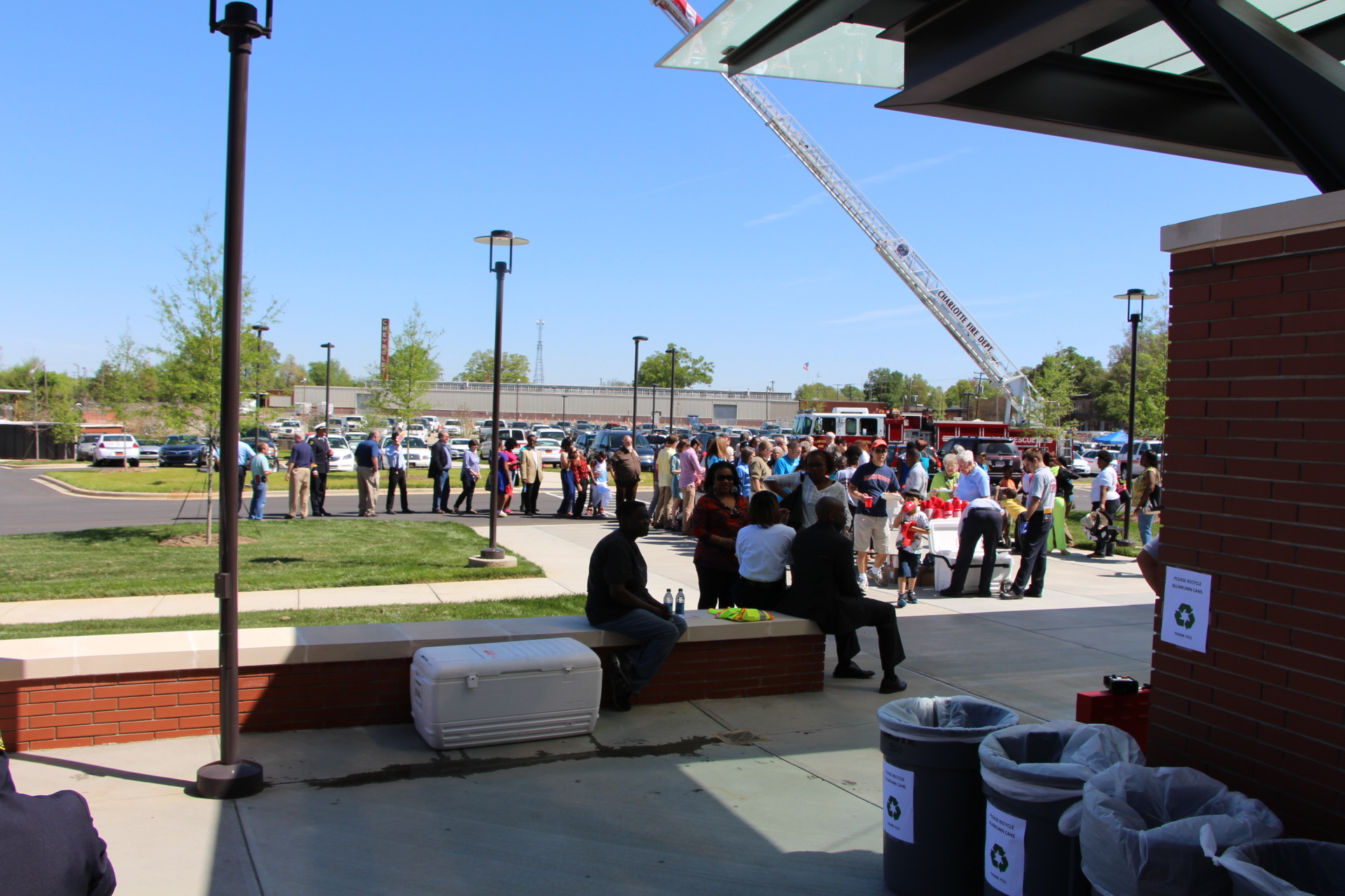 people gather outside a large firetruck with lots of space to sit on