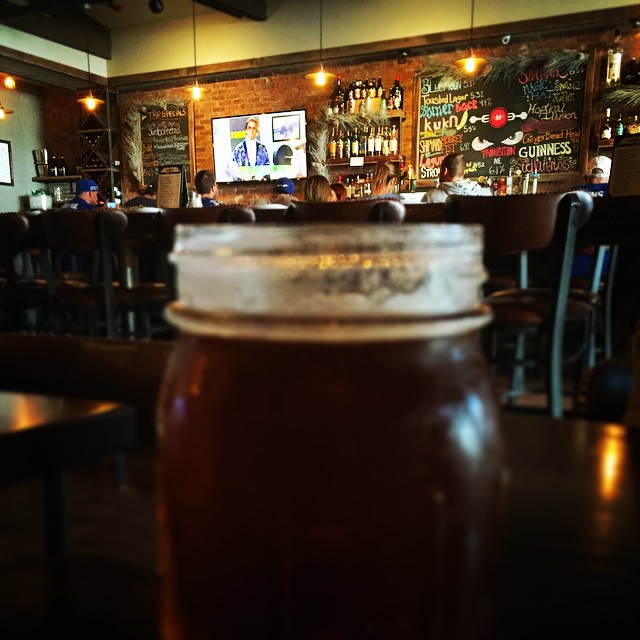 a jar of honey sitting on a table at a pub