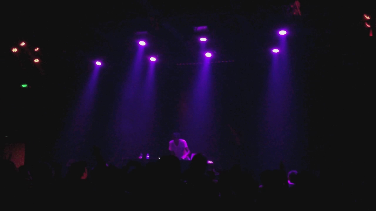 a person performing in front of purple spotlights