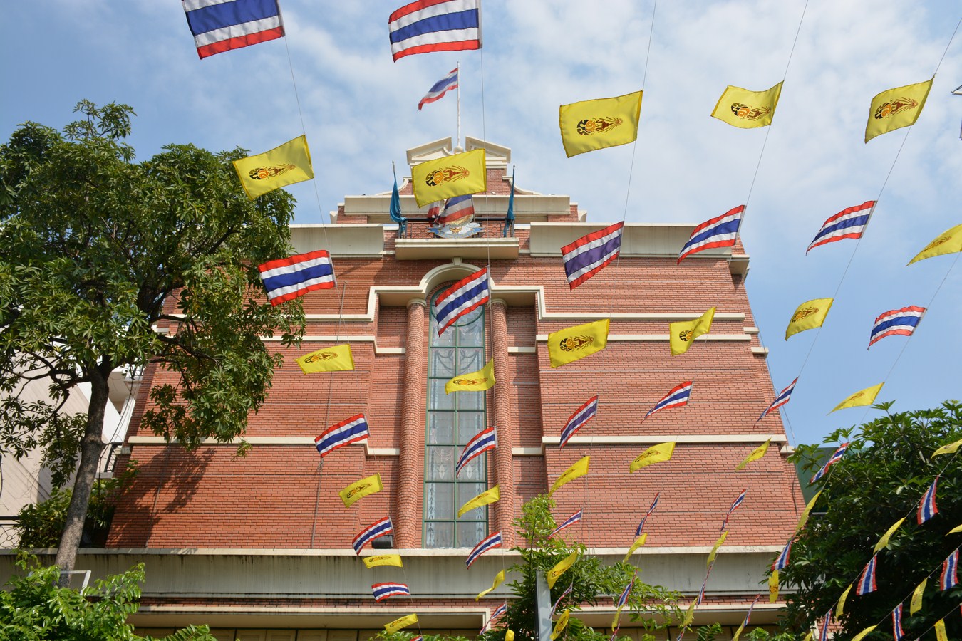 a building with a tower and many flags flying