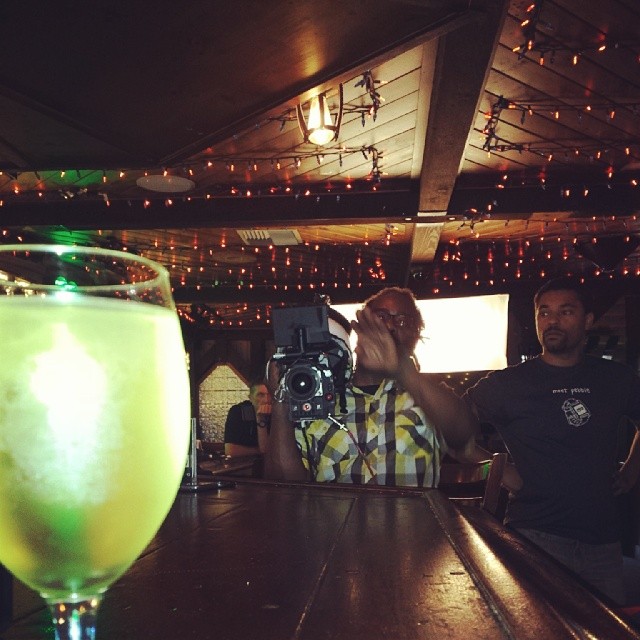 people at a bar with a neon colored beverage