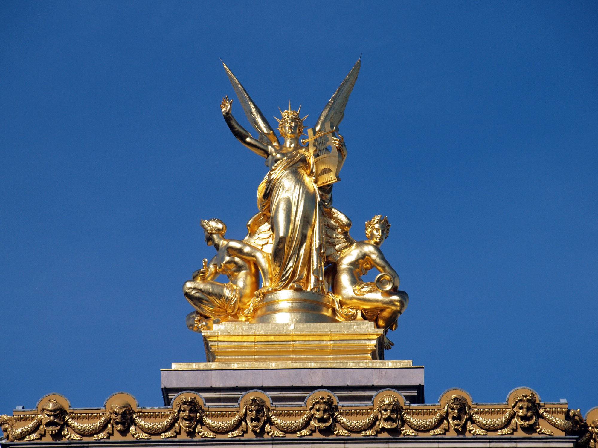 a golden statue with angel statues around it