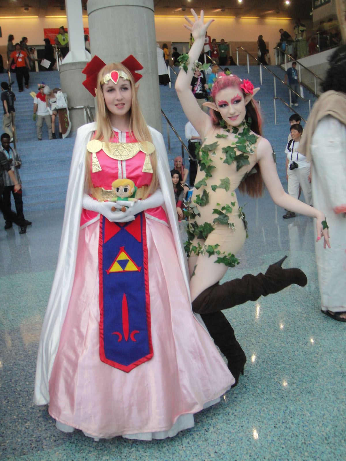 two women dressed as comic characters pose in front of a crowd