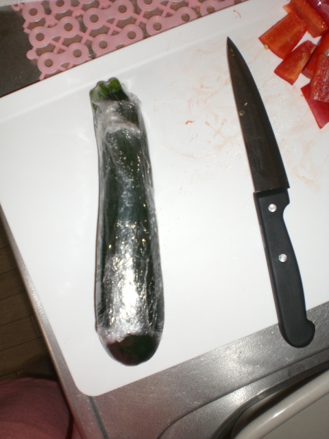 a knife sitting next to a sliced up cucumber on a table