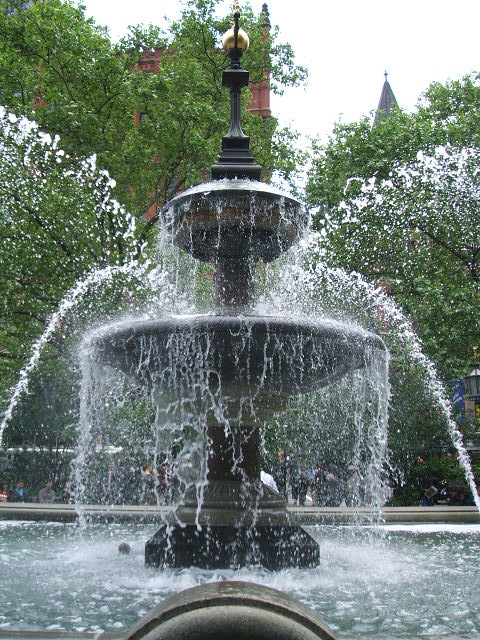 the water fountain is in front of some buildings