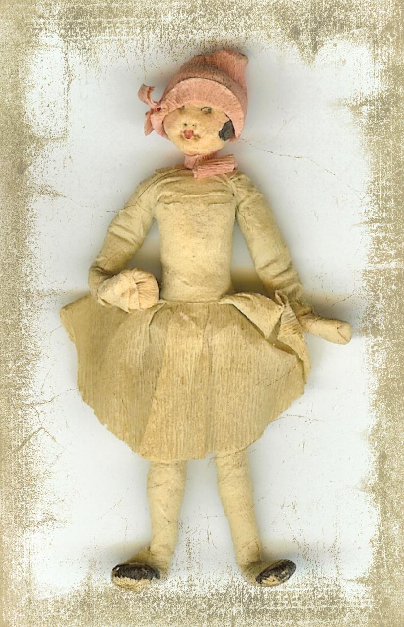 a small doll wearing a little dress and hat