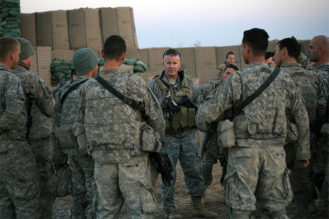 a man in camouflage is surrounded by military men