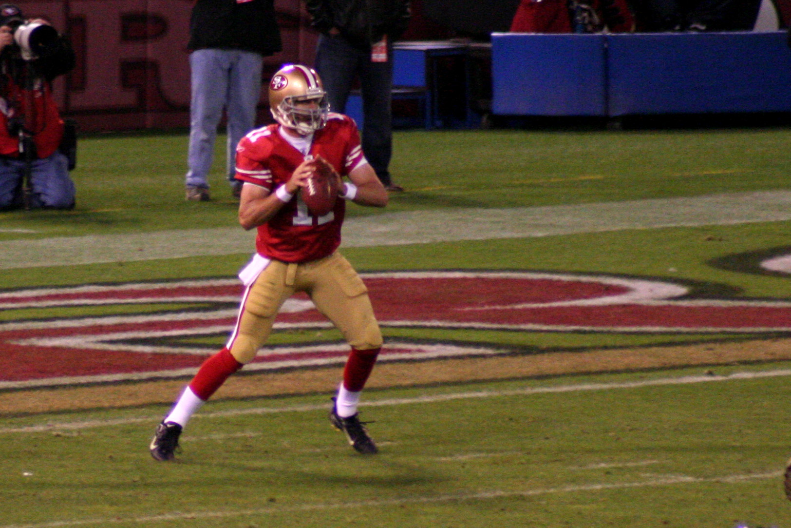 a football player in red and yellow jersey running on field