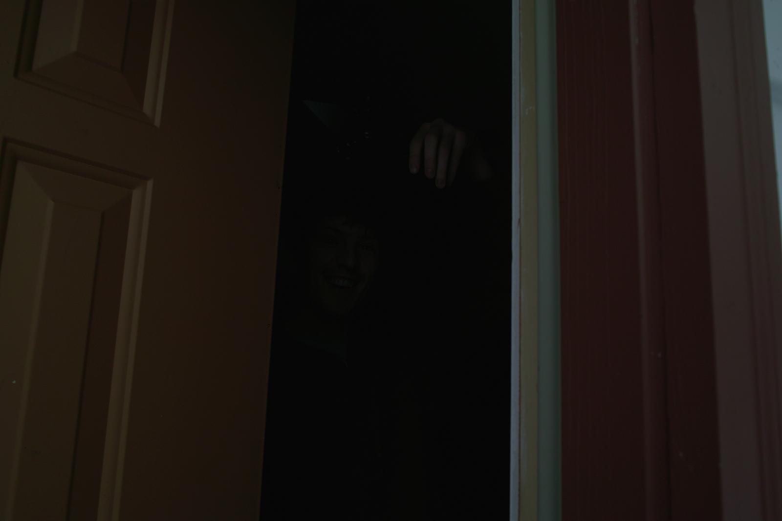 the silhouette of a man is seen through an opening in the door