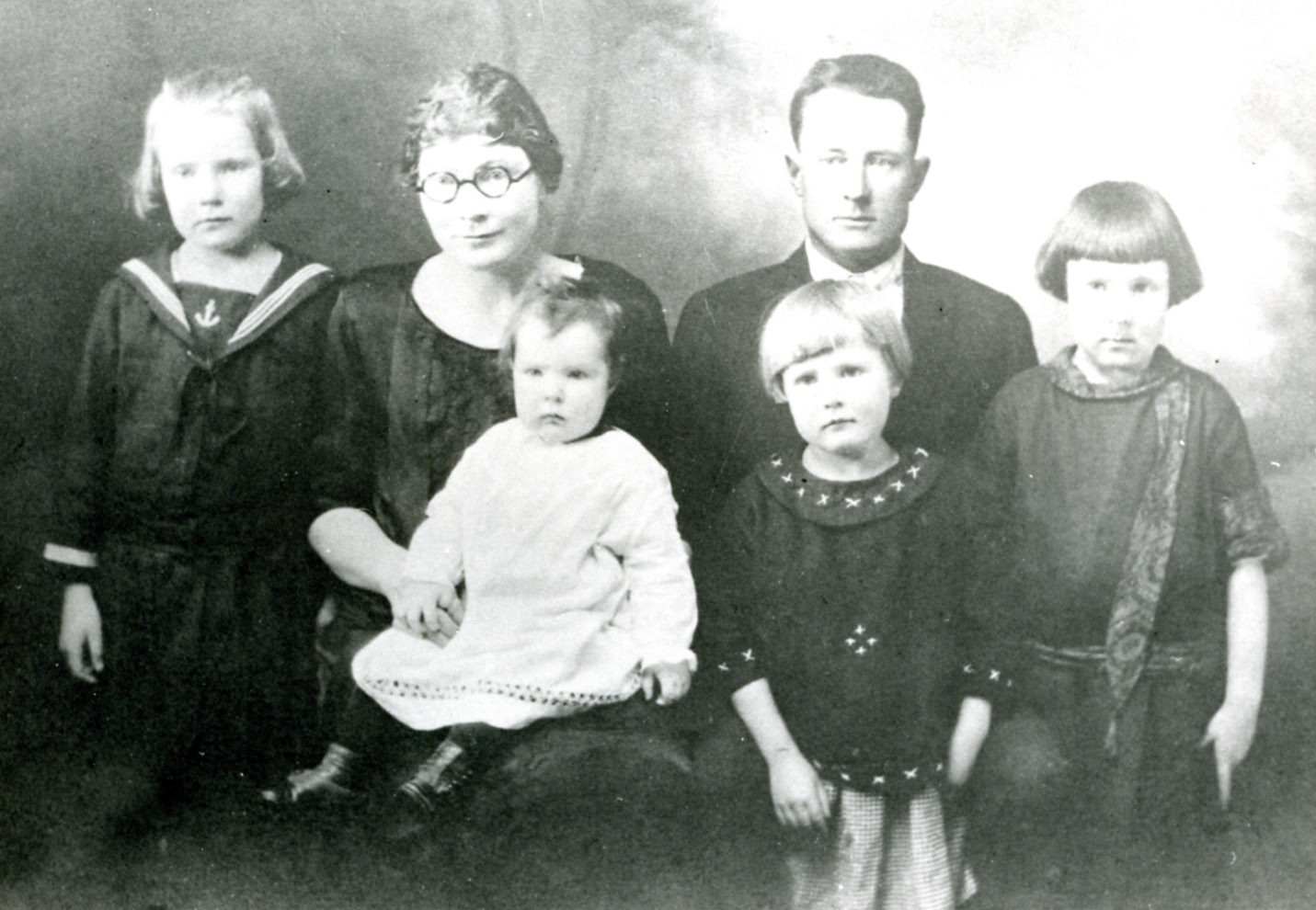 a group of adults with children, some in dress clothes