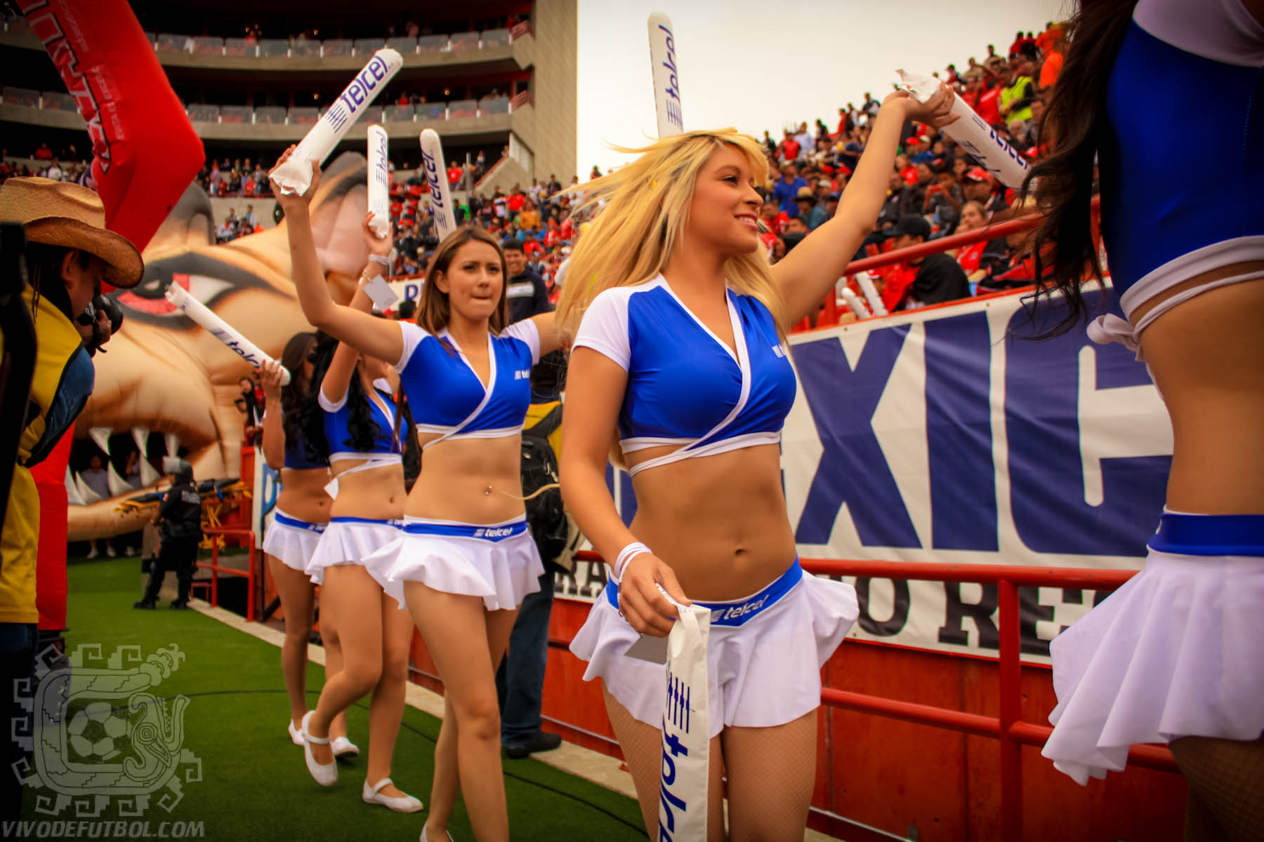 two cheerleaders at an event wearing blue and white outfits