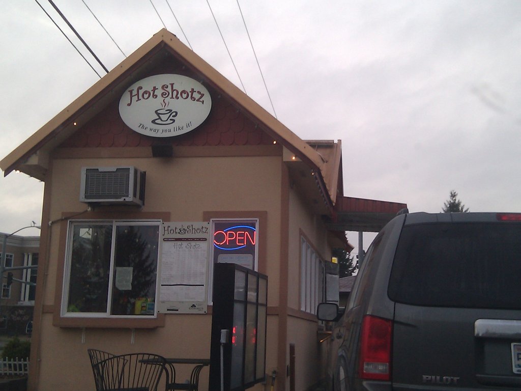 an outside view of a restaurant with cars parked in front