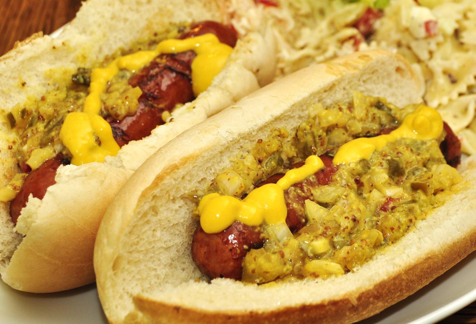 two dogs with mustard sitting on a plate