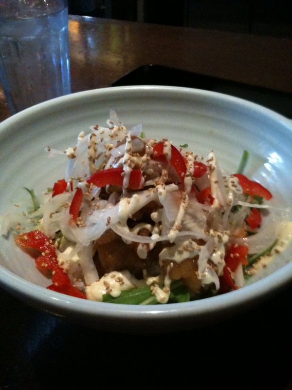 a small white bowl filled with food next to a water glass