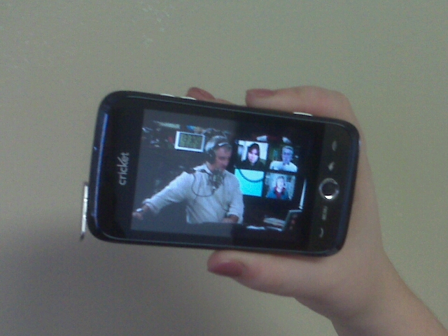 a person holding up a smart phone with a picture on the screen