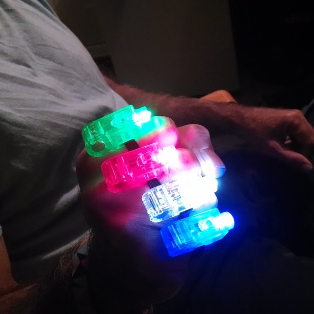 a person is holding three light - up led celets