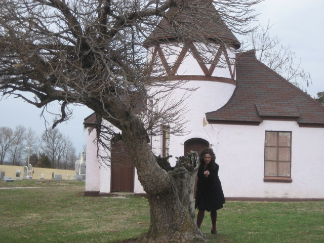 a woman walking away from a white church building