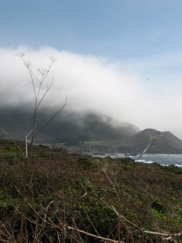 a view of a mountain with fog over the mountains