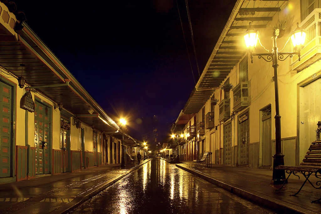 a street that has benches in it and lights on