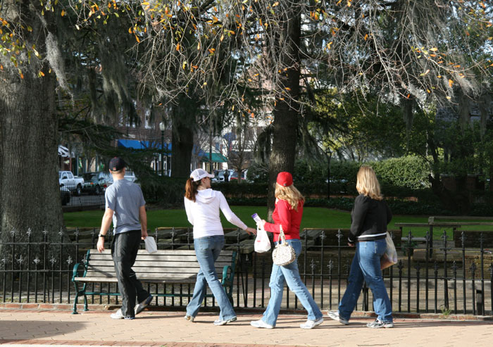 people walking and walking along the sidewalk in the park