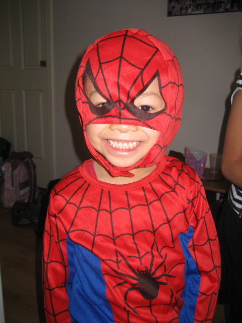young child in red and blue costume with spider man mask