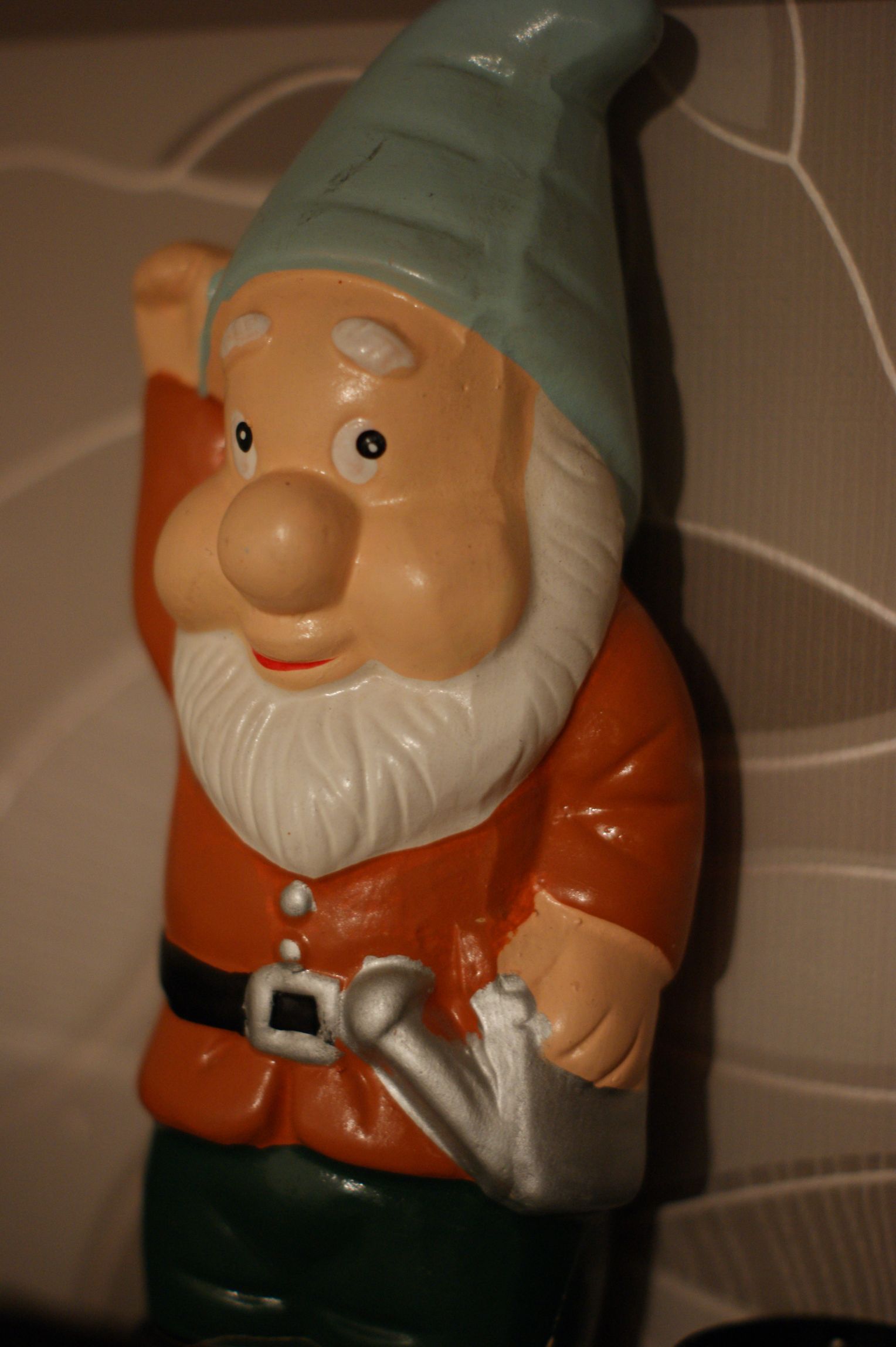 a green, white and orange gnome figurine on the wall