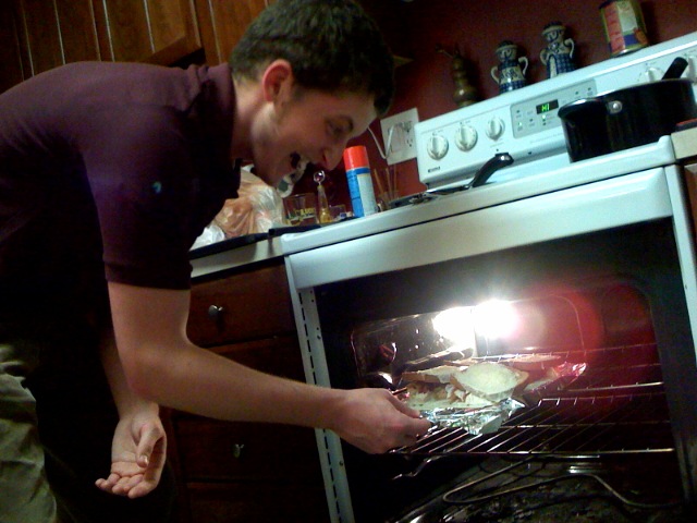 a man taking food out of an oven
