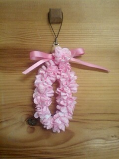 pink flower and ribbon wreath ornament on wood background