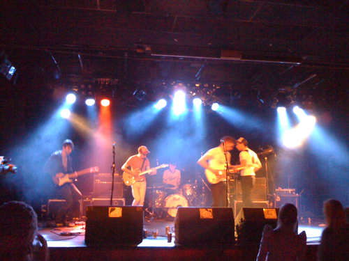 an image of band playing on stage in the dark
